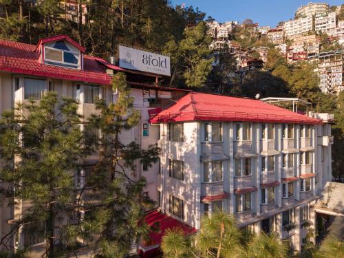 a building with a red roof on a mountain at 8fold by Larisa, Shimla in Shimla