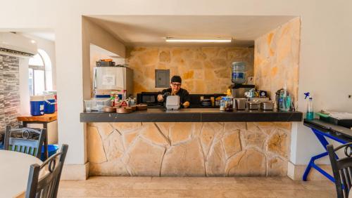 a woman sitting at a counter in a kitchen at Hotel María Bonita by Chavira in Nuevo Laredo