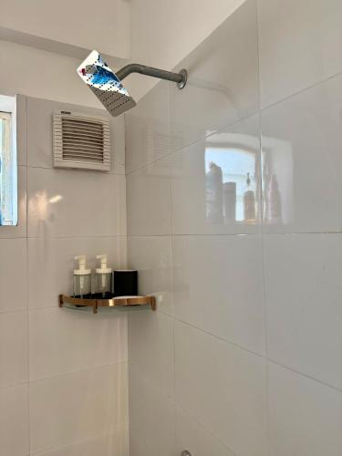 a bathroom with a shower with a light on the wall at Between Tides nd Toasts Udupi Manipal in Manipal