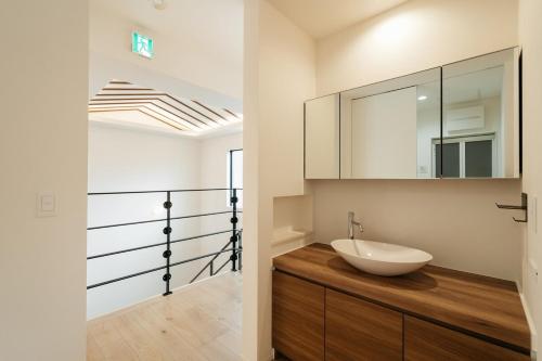 a bathroom with a sink and a mirror at MIRATIO Umui Sauna&Spa in Onna