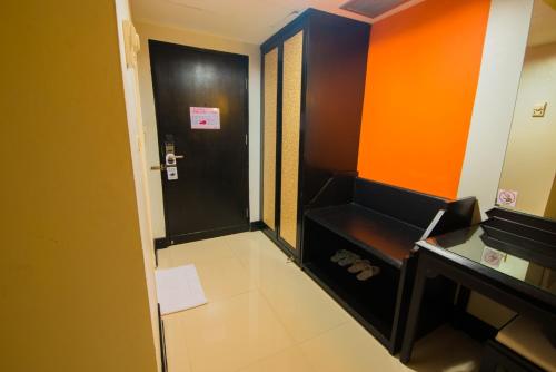 a small room with an orange and black door at Asawann Hotel Nongkhai in Nong Khai