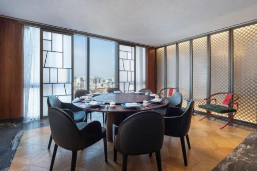 a dining room with a table and chairs in a room with windows at 마티네차움호텔 in Seoul