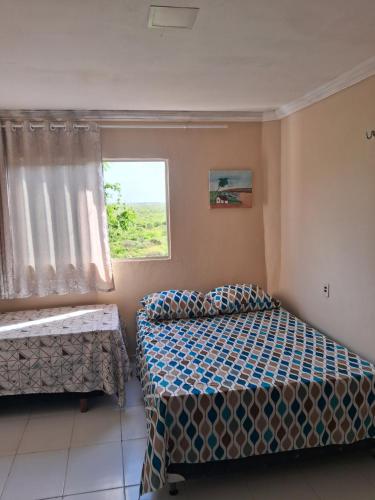 a bedroom with two beds and a window at Casa blue in Aracati