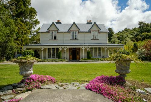 a large white house with flowers in the yard at Waikonini Homestead in Geraldine