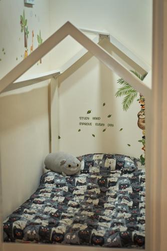 a bed with a teddy bear sitting on top of it at Airport SJO Inn in Santiago Este