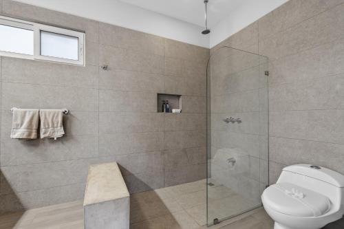 a bathroom with a toilet and a glass shower at The Point 23 At Playa Avellanas in Playa Avellana