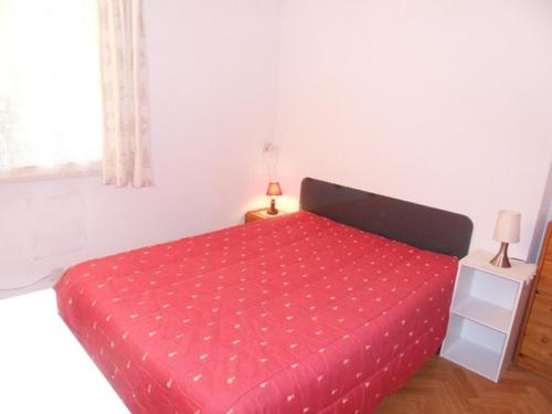 - une chambre avec un lit rouge et une couette rouge dans l'établissement Apt 4 pers - 200 m de la plage - Terrasse - CONGARD, à Kervernoïs