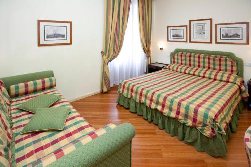 a hotel room with two beds and a couch at Hotel Italia in Siena