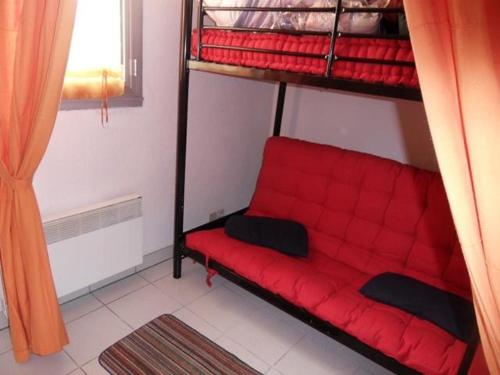 a red couch sitting on top of a bunk bed at Apt 4 à 5 personnes magnifique vue mer, terrasse - 50 m de la plage -MELWENN in Le Fort-Bloqué