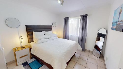 a bedroom with a white bed and a window at Noordhang Nest in Four Ways