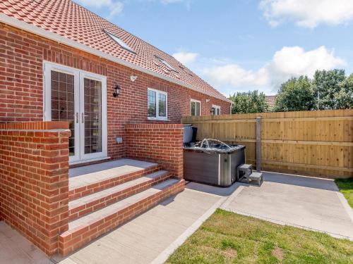 a barbecue on a patio next to a brick house at Dawson Park 6 - Uk12665 in Mablethorpe