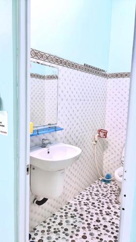 a white bathroom with a sink and a mirror at Hotel Kim Ngân Đảo Lý Sơn in Ly Son