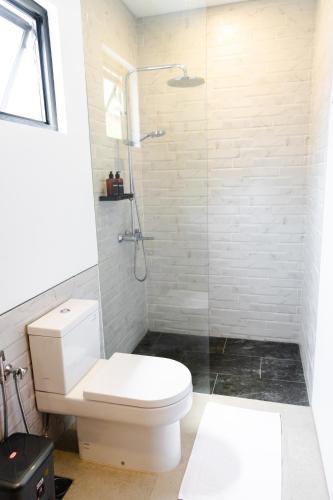 a bathroom with a toilet and a glass shower at Manse 만세 Villa in Ciburial