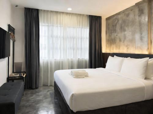 a bedroom with a large white bed and a window at Muari Boutique Hotel in Muar