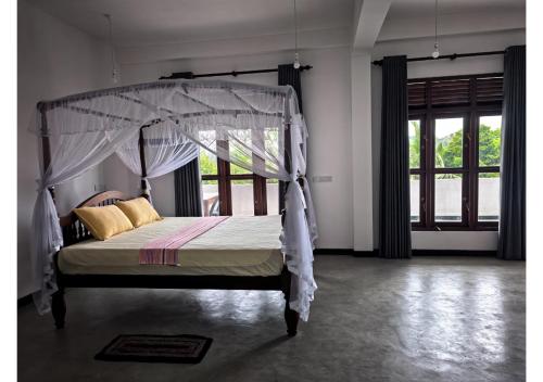 a bedroom with a bed with a canopy at Thotupola Villa - Mirissa in Mirissa