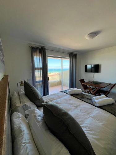 a bedroom with a couch and a view of the ocean at Sea Spray B103 in Cape Town