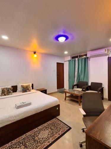 a bedroom with a bed and a table and a couch at Hotel serenity villa in Guwahati