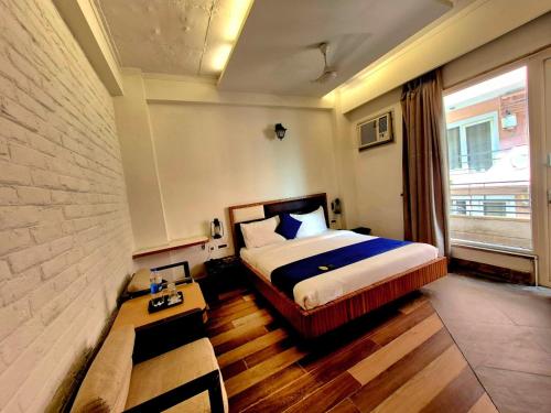 a hotel room with a bed and a window at Stays - Golf Course Road in Gurgaon
