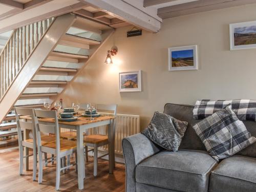 a living room with a couch and a table at Gable End Cottage in Ingleton