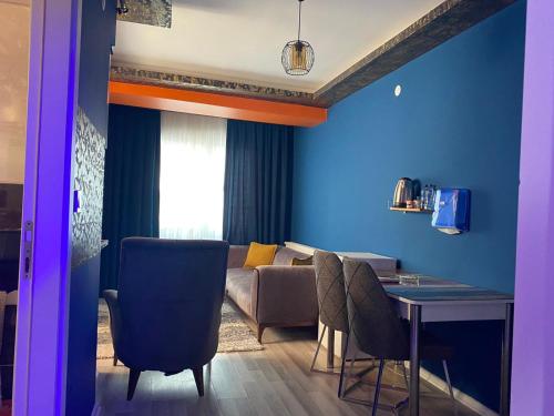a living room with a couch and a table with chairs at Royal Palace Boutique Otel Boudja in Buca