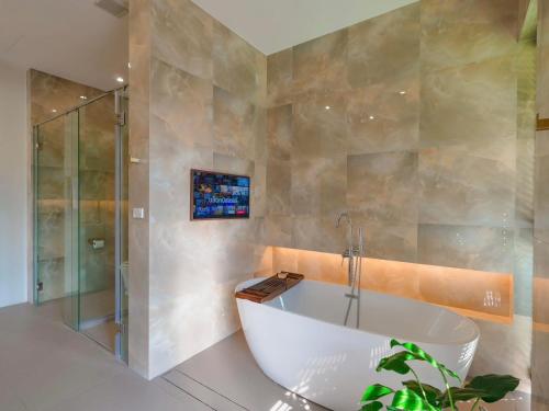 a bathroom with a tub and a glass shower at Solune Khaoyai Pool Villa in Ban Rai Khlong Sai
