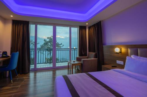 a hotel room with a bed and a balcony at Wisteria Crystal Manor in Pelling