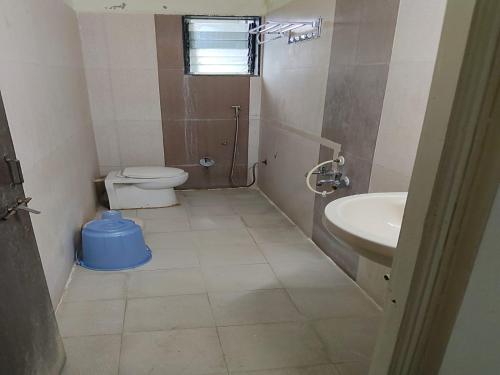 a bathroom with a toilet and a sink at Hotel Sai Palace Executive Lodging in Bīr