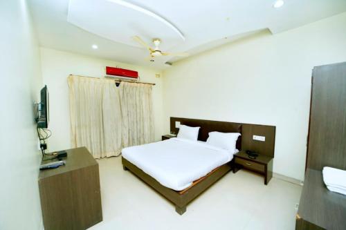 a bedroom with a bed and a desk and a television at Hotel Sai Palace Executive Lodging in Bīr