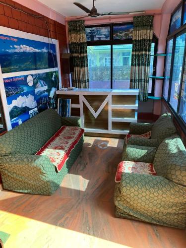 Hotel Marcopolo في Pokhara: غرفة معيشة بها أريكتان وطاولة