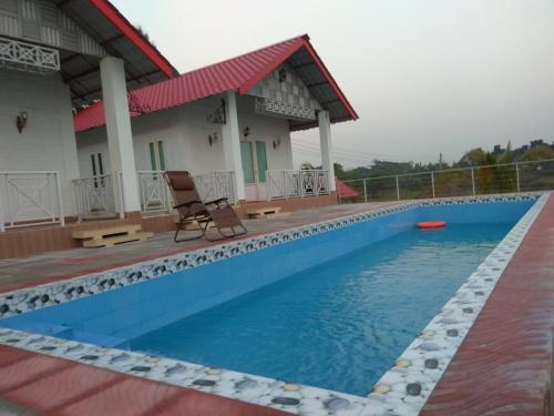 a large swimming pool in front of a house at Eastern Heritage Resort in Mymensingh