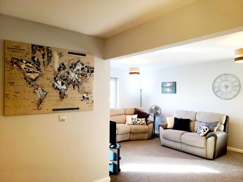 a living room with two couches and a map on the wall at Parkside Apartment Normanton in Wakefield