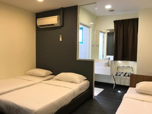 una camera con due letti e un bagno con specchio di L Hotel at 51 Desker a Singapore