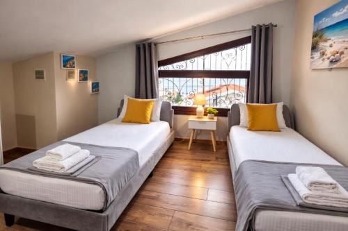 two beds in a room with a window at Teo`s Seaview Specious Apartment, Nikiti near Harbor in Nikiti