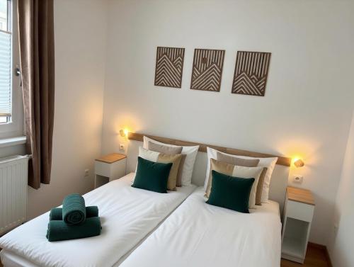 a bedroom with a large white bed with green pillows at Ferienwohnung Am Pillersee in Sankt Ulrich am Pillersee
