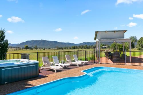 a swimming pool with chairs and a gazebo at Maranda Country Estate 5 Bedrooms with Pool, Spa & EV in Broke