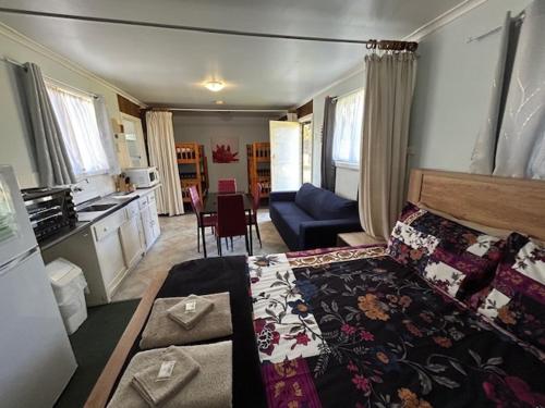a bedroom with a large bed and a kitchen at KI Caravan Park, Kingscote in Kingscote