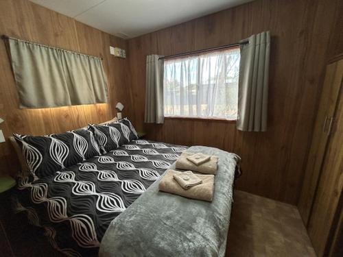 a bedroom with a bed with two towels on it at KI Caravan Park, Kingscote in Kingscote