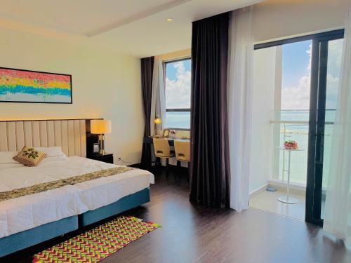 a bedroom with a bed and a desk and a window at Sapphire Residence Hạ Long in Ha Long