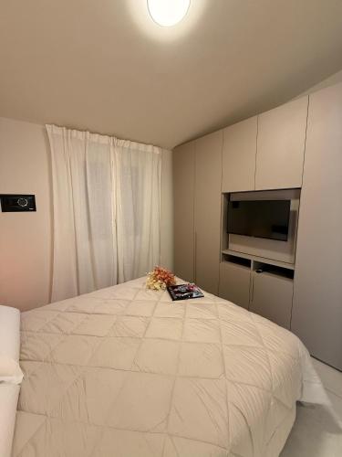 a bedroom with a large white bed with a flat screen tv at CASA Virginia - DEEP BLUE in Predore
