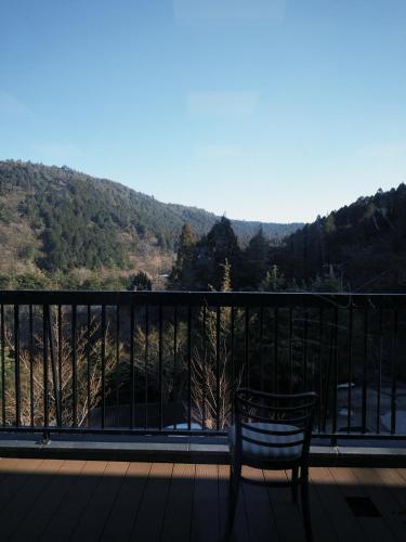 a bench sitting on a balcony with a view of a mountain at 光沙の森 in Hakone