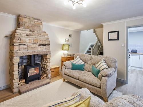 a living room with a couch and a fireplace at Cobblers Cottage in Barnard Castle