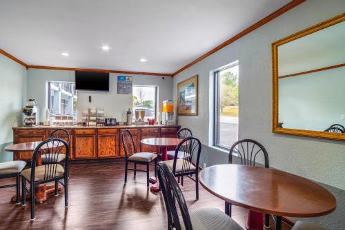 a dining room with tables and chairs and a kitchen at Rodeway Inn & Suites Fort Jackson in Columbia