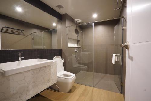 a bathroom with a toilet and a sink and a shower at Naga Residence in Bangkok