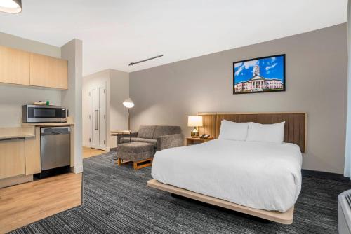 a hotel room with a bed and a kitchen at Alluxsuites at 1876, an Ascend Collection Hotel in Tallahassee