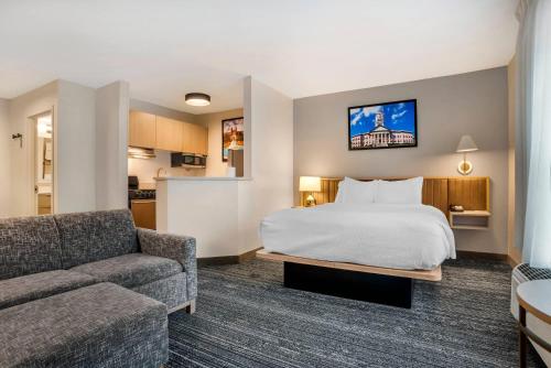 a hotel room with a bed and a couch at Alluxsuites at 1876, an Ascend Collection Hotel in Tallahassee