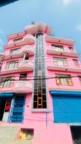 a pink building with blue doors in front of it at Parbat unique guest house in Kathmandu