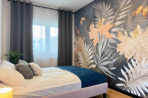 a bedroom with a bed with a floral wall at Apartament Stara Fabryka 15 in Włocławek