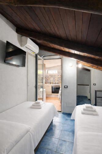 two beds in a room with a view of a kitchen at BeB il Vicoletto in Maratea