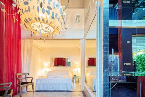 a hotel room with a bed and a chandelier at Riviera Golf Resort in San Giovanni in Marignano