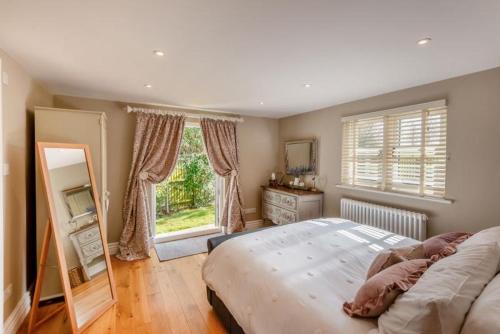 a bedroom with a large bed and a large window at The Gate Lodge - Pet Free - Near Finchingfield & Saffron Walden in Great Sampford